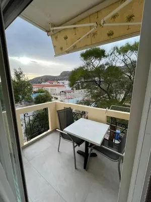 a table and chairs on a balcony with a view at Mediterranean Sea Top Floor in Palaiochóra