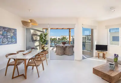 a living room with a table and chairs at Calmaliving Seaside apartments with pool in Gerani Chanion