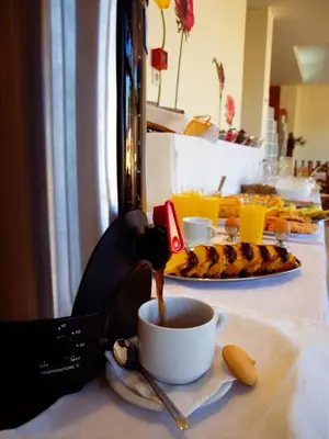 a cup of coffee on a table with a plate of food at Kissamos Hotel in Kissamos