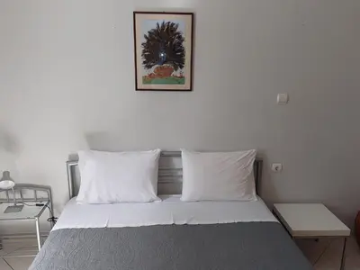 a bed with white pillows and a picture on the wall at Sonia cyclamen in Chania Town