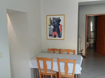 a dining room table with a white table and chairs at Sonia cyclamen in Chania Town