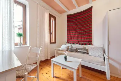 a living room with a couch and a red window at KasteliSuites in Chania Town