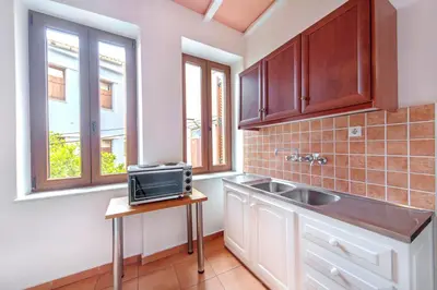 a kitchen with a sink and two windows at KasteliSuites in Chania Town