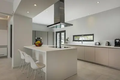 a kitchen with white cabinets and white counters at Villa Pirgos Luxury in Kissamos