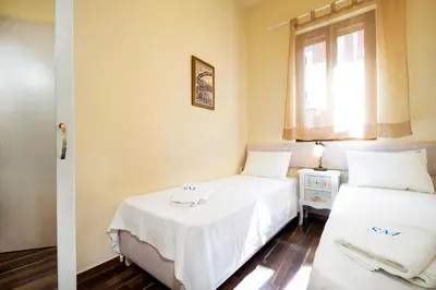 a bedroom with two beds with white sheets and a window at Suite Maritime in Chania Town