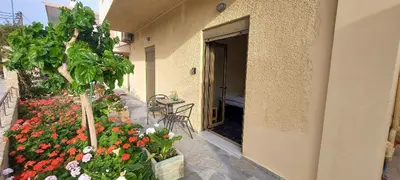a building with a garden of flowers in a courtyard at Casa.Costiera in Palaiochóra