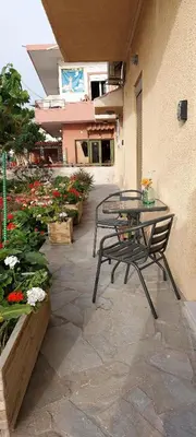 a patio with a table and chairs and flowers at Casa.Costiera in Palaiochóra