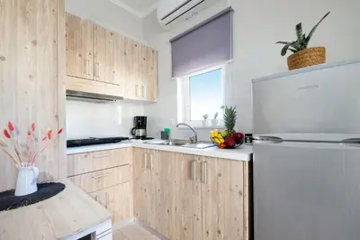 a kitchen with wooden cabinets and a stainless steel refrigerator at Casa Maria 300 meters from the sea in Chania Town