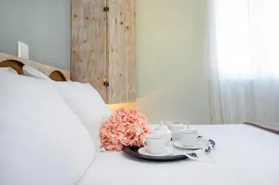 a table with two cups and saucers on a bed at Casa Maria 300 meters from the sea in Chania Town