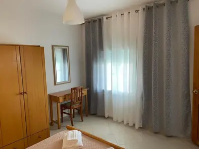 a bedroom with a table and a window with curtains at Claudia villa 2 in Agia Marina Nea Kydonias