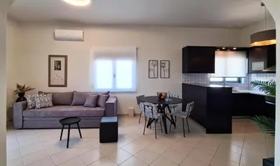 a living room and kitchen with a couch and a table at Anna & Zampia central apts in Kissamos