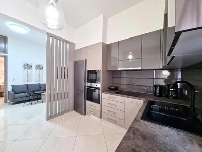 a kitchen with stainless steel appliances and a living room at Anna & Zampia central apts in Kissamos