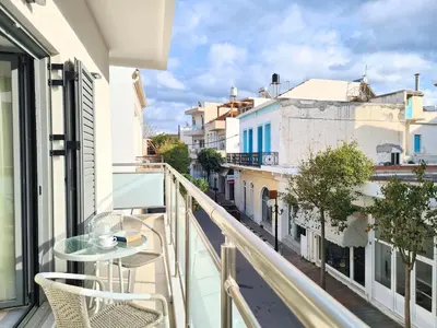 a balcony with a table and chairs and a view of a city at Anna & Zampia central apts in Kissamos