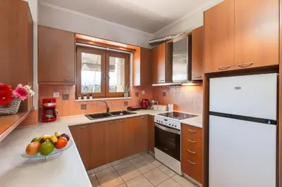 a kitchen with a white refrigerator and a bowl of fruit at Stema City Apartment in Chania Town