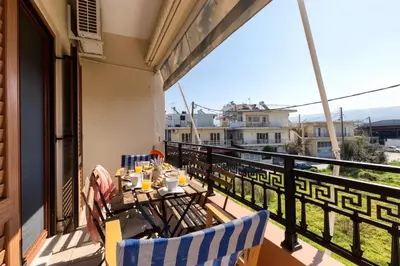 a balcony with a table and chairs on a balcony at Stema City Apartment in Chania Town