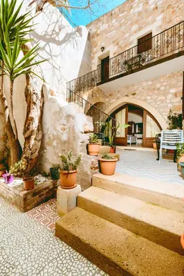 a stone building with stairs and potted plants at Bozzali Deluxe Hotel in Chania Town