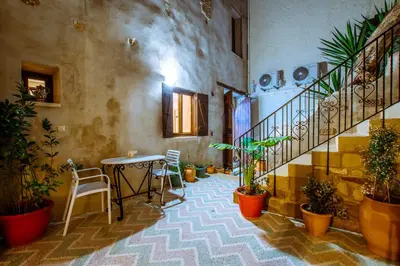 a room with a table and a staircase with plants at Bozzali Deluxe Hotel in Chania Town