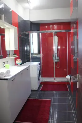 a bathroom with red walls and a shower with a sink at Kallia's Modern Apartment in Kissamos
