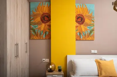 a bedroom with three paintings of sunflowers on the wall at Halepa Luxury Apartments in Chania Town