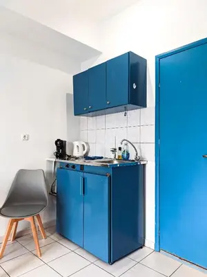 a kitchen with blue cabinets and a chair at Beautiful apartment in Chania in Chania Town