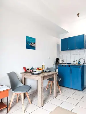 a kitchen with a wooden table and blue cabinets at Beautiful apartment in Chania in Chania Town