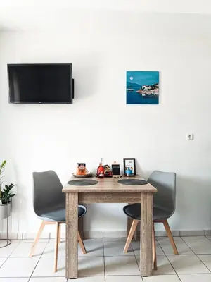 a dining room table with two chairs and a tv at Beautiful apartment in Chania in Chania Town