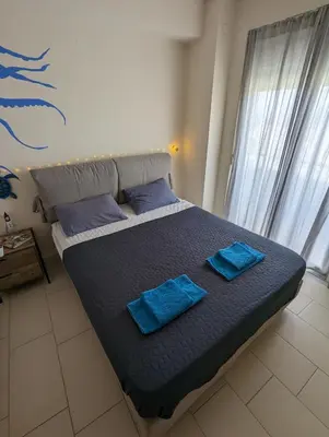 a bed with two blue pillows on it in a bedroom at Tamar's place in Chania Town