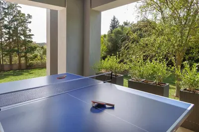 a ping pong table in front of a large window at SeaSilia Luxury Villa in Korakiaí