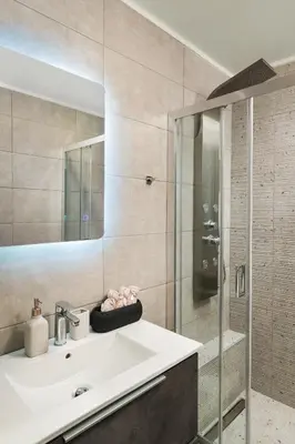 a bathroom with a white sink and a shower at 2 bd downtown home with private parking 400 meters walk to the beach in Chania Town