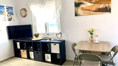 a dining room with a table and a television at D&R Sunshine Apartment in Agia Marina Nea Kydonias