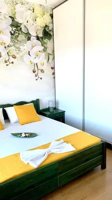 a bedroom with a bed with a flower mural on the wall at D&R Sunshine Apartment in Agia Marina Nea Kydonias