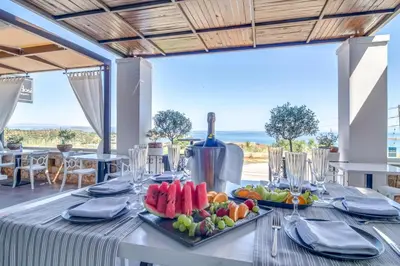 a table with food on it with a view of the ocean at Alexis Hotel in Chania Town