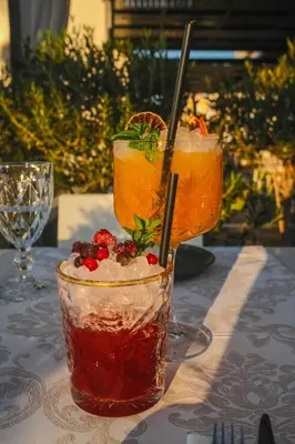 two cocktails sitting on top of a table at Alexis Hotel in Chania Town