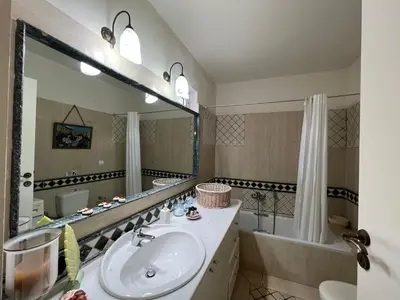 a bathroom with a sink and a mirror and a tub at Ammos Beachfront House by 8essentially in Kato Daratso