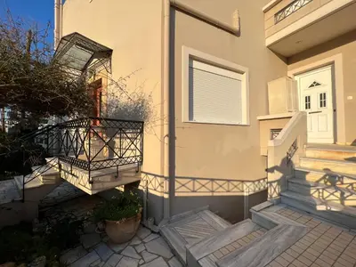 a house with stairs and a door with a balcony at Ammos Beachfront House by 8essentially in Kato Daratso