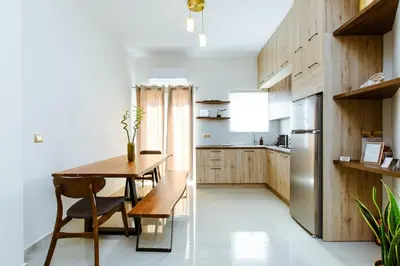 a kitchen with a wooden table and a stainless steel refrigerator at Porfyra Suite 2 in Chania Town