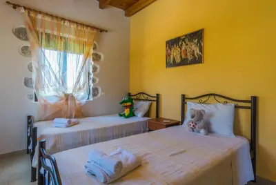 two beds in a bedroom with a teddy bear sitting between them at Villa Vicina - In Platanias and 4min by the beach in Chania Town