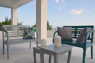 two benches sitting on a patio with a table at Villa Sobre - Spacious and Comfortable. in Kounoupidhianá