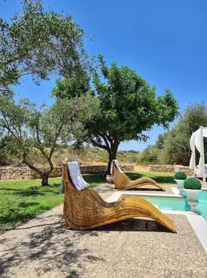 a pair of wooden benches sitting next to a pool at Villa Sobre - Spacious and Comfortable. in Kounoupidhianá