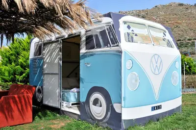 a blue and white van parked in a field at Cornelia Hippie Magic Bus in Kissamos