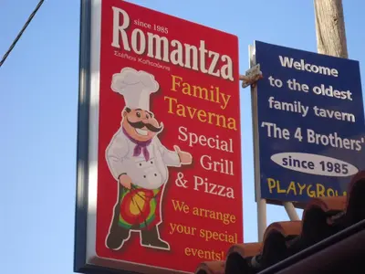 a sign for a restaurant with a chef on it at ROMANTZA apartments in Agia Marina Nea Kydonias
