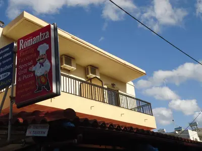 a sign for a restaurant on the side of a building at ROMANTZA apartments in Agia Marina Nea Kydonias