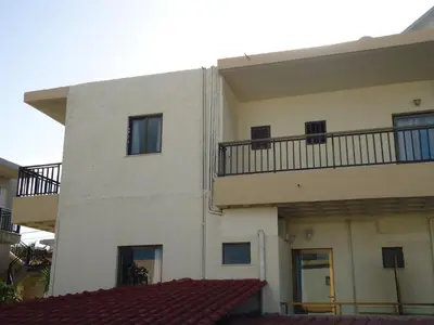 a white building with a balcony on the side of it at ROMANTZA apartments in Agia Marina Nea Kydonias