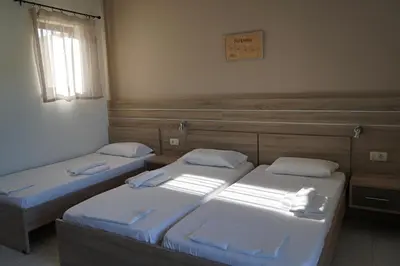 two twin beds in a room with a window at ROMANTZA apartments in Agia Marina Nea Kydonias