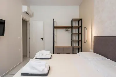 a white room with two beds and a ladder at Orama Luxury Apartments in Agia Marina Nea Kydonias