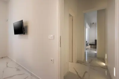 a hallway with a television on a white wall at Orama Luxury Apartments in Agia Marina Nea Kydonias
