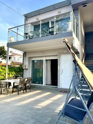 a house with a balcony and a table and chairs at Beachfront villa Agia Marina in Stalos