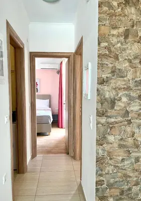 a hallway leading to a bedroom with a stone wall at Beachfront villa Agia Marina in Stalos