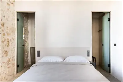a bedroom with a white bed and two doors at PETRA - casa casa group in Chania Town