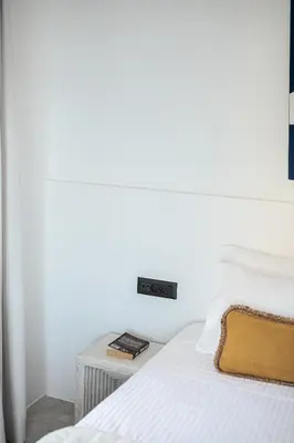 a white bedroom with a bed and a table at ALS - casa casa group in Chania Town